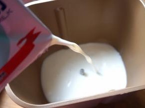 面包机内桶清洗干净，先将一袋鲜牛奶倒入桶中