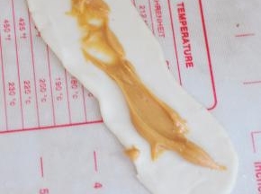 在面皮中间，挤上花生酱。