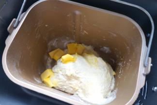 一个揉面程序后，面团有些筋度了，将软化的黄油入桶中，继续完成剩下的揉面程序