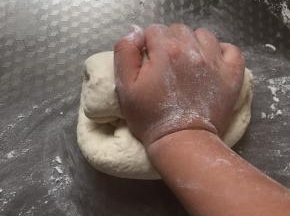 在案板上撒些面粉，以手腕的力量继续揉均匀。