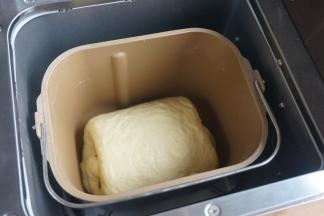 将搅拌棒取出，红豆沙面包卷放入面包桶中，这样烤出来的面包底部没有大洞；重新设定程序，选择“发酵酸奶”程序，待面团的涨发到原来的2倍大时，停止发酵