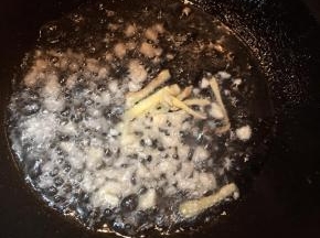 锅中加入油，大火烧热，放入蒜末和姜丝煸出香味。