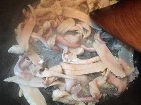 倒入鱿鱼干大火不停的翻炒。