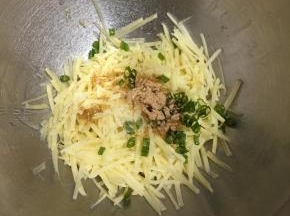 土豆丝放入容器中，加入葱末，调入盐和鸡精，再加入椒盐粉。