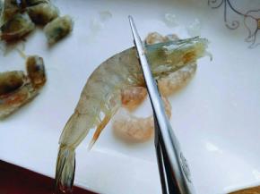 再把虾头剪下来，虾头不要丢掉。放在容器里备用，全部这样做完。