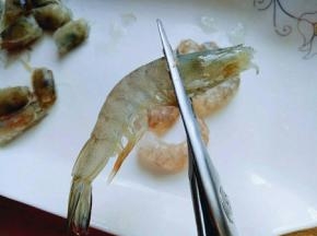 再把虾头剪下来，虾头不要丢掉。放在容器里备用，全部这样做完。