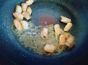 虾头炒至颜色变红，加入一勺料酒，小火煸炒，料酒可以去掉虾的腥气。