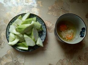 丝瓜滚刀切，切菱形块，鸡蛋碗里加入葱，蒜，十三香，熟白芝麻用筷子打散。