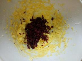 切碎的蔓越莓加入打发的黄油容器中。