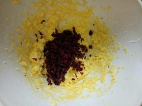 切碎的蔓越莓加入打发的黄油容器中。