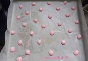将粉红色的蛋糕糊装进一次性裱花袋里，剪个小口，在烤盘上挤出小圆点后（提前将烤盘铺好油纸），放入烤箱180度，烤3分钟，取出晾凉；