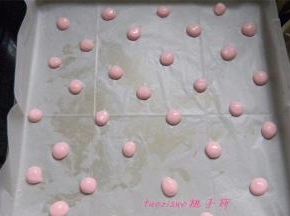 将粉红色的蛋糕糊装进一次性裱花袋里，剪个小口，在烤盘上挤出小圆点后（提前将烤盘铺好油纸），放入烤箱180度，烤3分钟，取出晾凉；