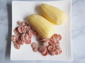 土豆洗净去皮，香肠切成薄片。