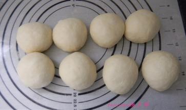 将发好的面包面团按每个70克分成小面团，滚圆后静置30分钟；