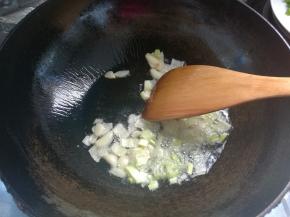 放入葱碎、蒜片爆香。