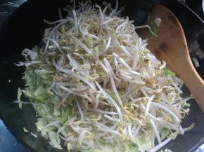 放洋白菜丝、放入红萝卜丝煸炒至八分熟。