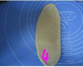 松弛好的面团按扁，擀成椭圆形；