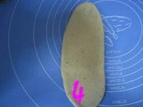 松弛好的面团按扁，擀成椭圆形；