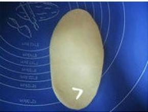 取一面团，擀成长约16cm、宽约10cm的椭圆形；