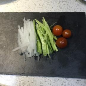 黄瓜与白萝卜切丝，夹到盘子上摆盘，小番茄也放上