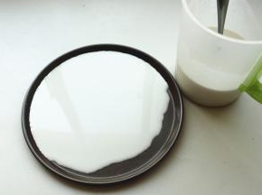 找一个不沾的平盘，我用了披萨盘，舀入适量面糊，转动盘子使面糊铺满盘子。