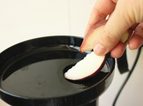 桃子块从投料口投入机器，必要时候用推杆推一下。
