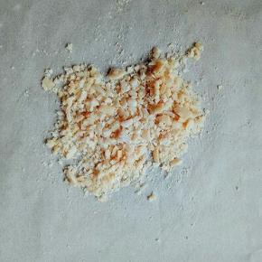 将去皮的熟花生碾碎，用擀面杖来回擀。