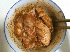 加入少许清水，用筷子搅拌均匀，让孜然烤料都均匀的裹在鸡中翅上，盖好保鲜膜入冰箱冷藏过夜。