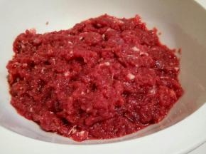 剁好的牛肉馅，放在一个相对高一点的容器里(这样搅拌的时候可以省点力)460的牛肉，我放了105克的鸡汤，循序渐进地倒入，一边倒，一边拌，直到牛肉吸收