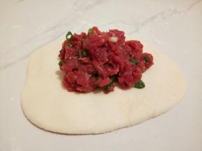 分成小的面团，我做了9个，皮薄馅大，取其中大一个面团，擀圆，包上牛肉馅，