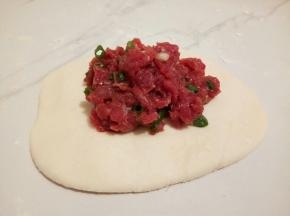 分成小的面团，我做了9个，皮薄馅大，取其中大一个面团，擀圆，包上牛肉馅，