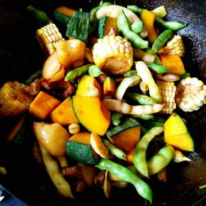 把准备好的豆角，倭瓜，土豆，玉米统统倒入锅中翻炒，炒至豆角变色，加入适量清水，大火烧开后转中火满炖。