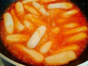 加入没过年糕的水，大火烧开，直到汤汁黏稠即可。品尝一下味道，如果觉得味道不够，可以加入盐和糖调味。