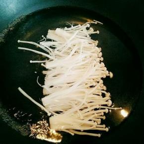 金针菇切去根，洗干净，放入锅中煮熟。(金针菇放入锅中时不要去翻动，以免乱了，包的时候不好包。)煮熟后捞出淋干水分。