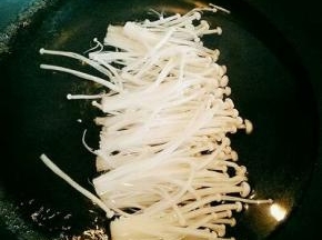 金针菇切去根，洗干净，放入锅中煮熟。(金针菇放入锅中时不要去翻动，以免乱了，包的时候不好包。)煮熟后捞出淋干水分。