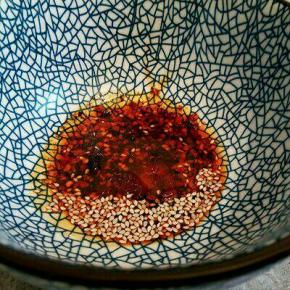 碗里放少许芝麻，芝麻油一勺，生抽一勺，盐，味精少许，倒入高汤(高汤可以用猪骨或者鸡架熬汤)，拌开，