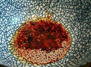 碗里放少许芝麻，芝麻油一勺，生抽一勺，盐，味精少许，倒入高汤(高汤可以用猪骨或者鸡架熬汤)，拌开，
