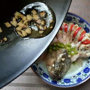 蒸好的鲈鱼会有些汤汁，把汤汁倒掉，红椒切丝，摆放再鱼背部，绿椒切丁，锅中放入适量油，加葱姜蒜，炒香，之后淋在蒸熟的鱼身上即可。