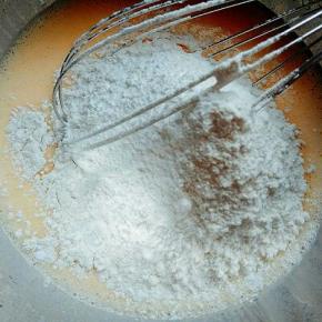 蛋黄容器中加入牛奶搅拌均匀，再加入玉米油搅拌均匀，再筛入低筋面粉翻拌均匀，提起打蛋器面糊可以顺畅流下。