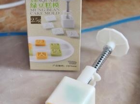 取两小块绿豆泥，和两小块原味豆泥，先塞进绿豆糕模具中，然后将原色的豆泥揉圆塞入，脱模后就完成了。