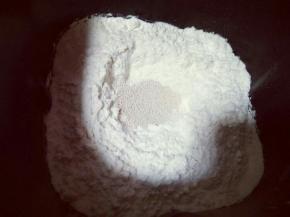 除黄油外的食材全部放入面包桶，以先放液体再粉类的顺序放，糖和盐对角放，再加入面粉，顶端挖个洞，加入酵母粉。再用面粉把酵母盖起来。
启动面包机，自动和面功能。20分钟