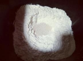 除黄油外的食材全部放入面包桶，以先放液体再粉类的顺序放，糖和盐对角放，再加入面粉，顶端挖个洞，加入酵母粉。再用面粉把酵母盖起来。
启动面包机，自动和面功能。20分钟