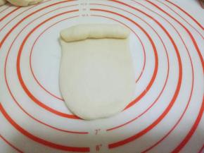 将擀好的长舌状从上到下卷起来，如图。