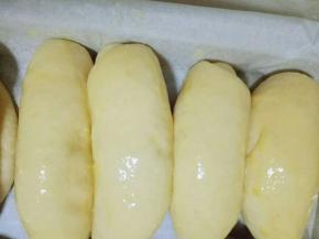 做完的面包胚放入垫有油纸的烤盘，并间隔一些缝隙，入烤箱进行二次发酵，(天冷的话烤盘下面放一碗开水，天热不需要。)
发酵好的面包胚是原来的两倍大，这时把烤盘取出，刷上蛋液，撒上葱花和白芝麻，进行烘烤，(喜欢吃肉松的还可以撒上肉松。)
烤箱180度预热5分钟，之后烤盘入烤箱中层，烤20分钟，注意观察颜色，具体温度及时间根据自家的烤箱另定。