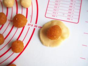 将面团压扁，放入凤梨馅，一点一点包住后收口朝下放置