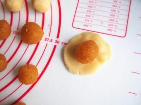 将面团压扁，放入凤梨馅，一点一点包住后收口朝下放置