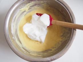 蛋白中加入几滴柠檬汁，分三次加入糖，打发至湿性发泡，取三分之一蛋白加入蛋黄糊中，切拌均匀