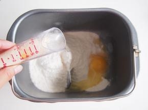 面粉放入面包桶，一侧放入鸡蛋、糖、盐，另一侧放入酵母。