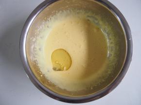 打发至蛋黄颜色变浅，糖基本溶化，并且蛋黄液变得浓稠有光泽，分三次加入玉米油，每次都搅拌均匀。