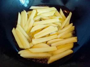 热锅冷油，油温8成时加入切好的土豆条。中火炸土豆条。
